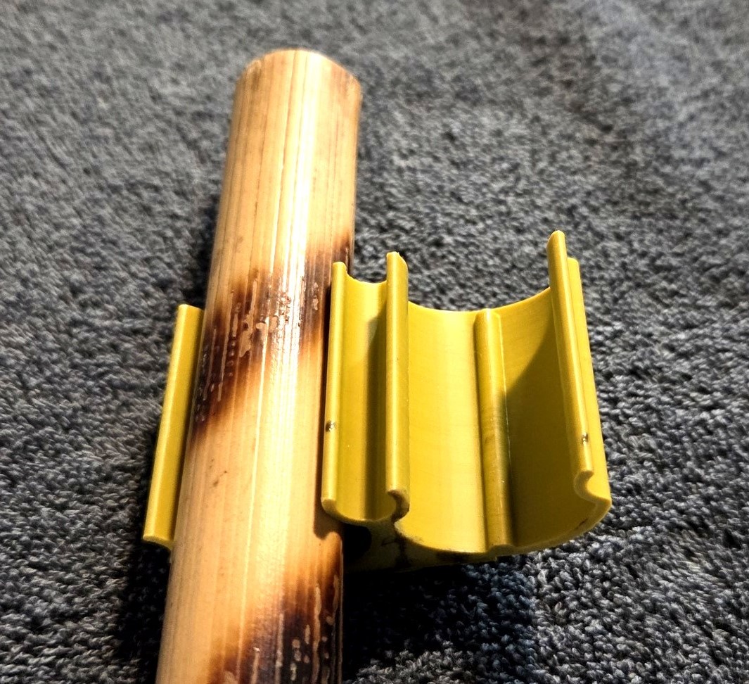 A single rattan stick being held in a double stick holder. A Kali Klip prototype.